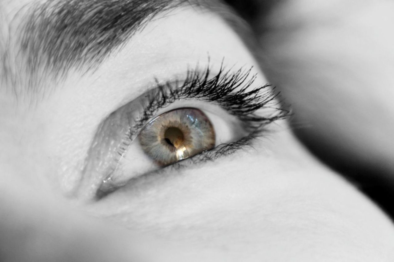 Close up black and white image of a ladies eye and eyelashes